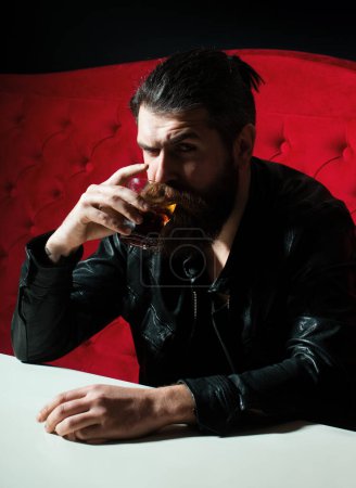Foto de Hombre barbudo bebiendo whisky, whisky o brandy de coñac. Hombre molesto bebedor alcohólico con vaso beber whisky solo, triste deprimido adicto - Imagen libre de derechos