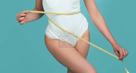 Photo for Woman waist with tape, weight loss. Female model body care. Woman holding the meter with hands and measuring waist. Trained belly with measuring tape - Royalty Free Image