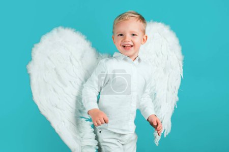 Photo for Beautiful little angel isolated. Valentines day. Cute child boy in white dress standing over blue background - Royalty Free Image