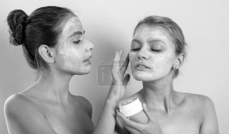 Photo for Girls friends sisters making clay facial mask. Anti age mask. Stay beautiful. Skin care for all ages. Women having fun cucumber skin mask. Pure beauty. Beauty product. Care and fun. Spa and wellness. - Royalty Free Image