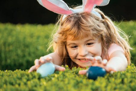 Photo for Kids boy hunting easter eggs. Child with easter eggs and bunny ears. Happy Easter kids face - Royalty Free Image