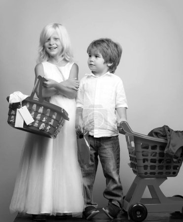 Photo for Girl and boy children shopping. Couple kids hold plastic shopping basket toy. Kids store. Mall shopping. Buy products. Play shop game. Cute buyer customer client hold shopping cart. Buy with discount. - Royalty Free Image