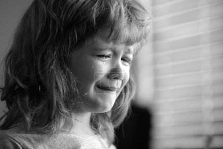 Foto de Cara de niño llorón. Niño triste con lágrimas en casa - Imagen libre de derechos