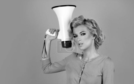 Foto de Mujer rubia en estilo retro gritando a través de un megáfono. Idea de marketing o banner de ventas - Imagen libre de derechos