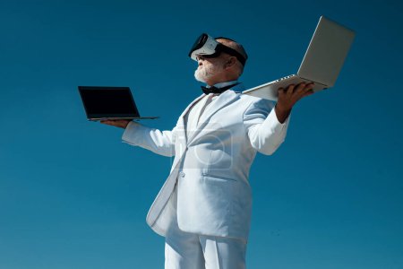 Téléchargez les photos : Vieil homme d'affaires dans vr. La réalité virtuelle. Concept technologique futur. Homme en 3d lunettes et ordinateur portable - en image libre de droit