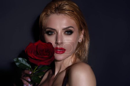 Foto de Studio beauty portrait of young beautiful sexy woman with red rose flower - Imagen libre de derechos
