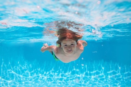 Foto de Niños bajo el agua nadando en la piscina, niños sanos nadando y divirtiéndose bajo el agua. Actividades de verano para niños, deportes acuáticos - Imagen libre de derechos