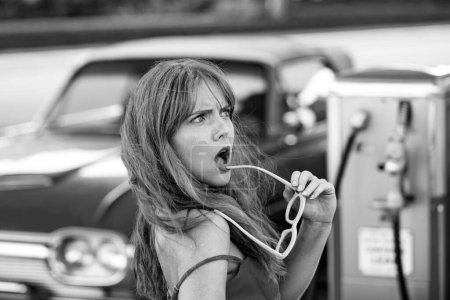 Foto de Gasolinera. Sensual mujer contra rojo retro automóvil - Imagen libre de derechos