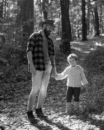 Téléchargez les photos : Amusement d'automne au parc. Papa et enfant rient tous les deux. Père et fils marchant ensemble dans le parc, jour d'automne - en image libre de droit