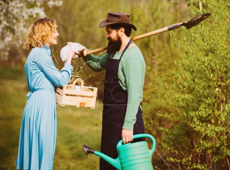 Foto de Esposa y marido plantando en el huerto. Jardinería en primavera: pareja feliz cosechando y divirtiéndose mucho - Imagen libre de derechos