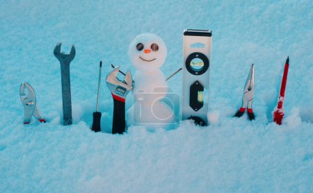 Téléchargez les photos : Outils de réparation. Bonhomme de neige avec instrument de réparation. Ouvrier homme de neige - en image libre de droit