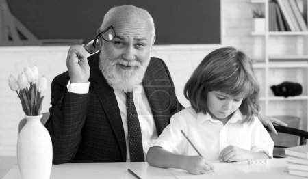 Photo for Help to learn. Old teacher with pupil. School lesson. Education concept. Old teacher with schoolboy in classroom - Royalty Free Image