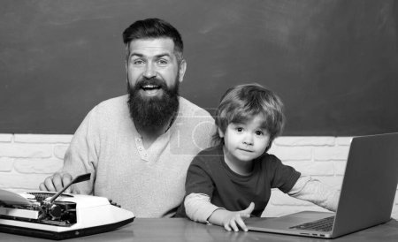Photo for Teacher helping kids with their homework in classroom at school. Back to school. Parent Teacher. Man teaches child. First day in school. Young adult concept. Father and son - Royalty Free Image