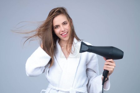 Téléchargez les photos : Beautiful young woman using a hair dryer - en image libre de droit