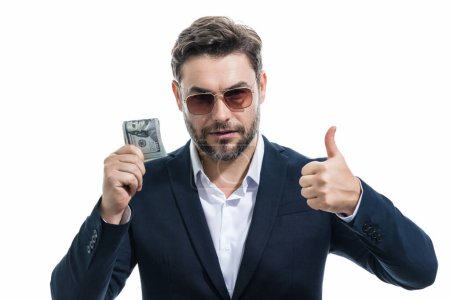 Photo for Good payment. Handsome business man holding money isolated over grey studio. Money in dollar banknotes. Pile of cash, finance, investment and money saving - Royalty Free Image