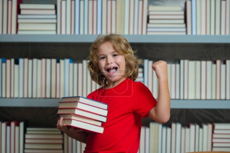 Photo for Amazed school kid hold stack of books. Successful excited school kid. Kid reads books in the library. Schoolboy with book in school library. Literature for reading. Child learning from books - Royalty Free Image