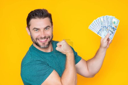 Business man in t-shirt with cash money dollars banknotes isolated on yellow studio background. Hundred dollar bill, financial concept