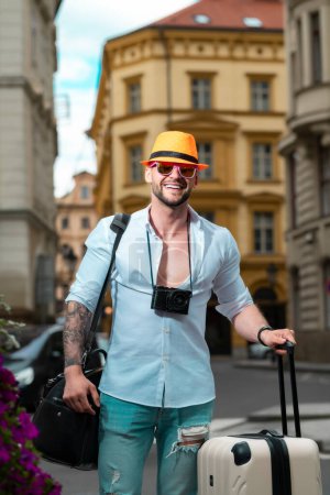 Foto de Hombre con equipaje de vacaciones, viaje. Turista hombre con bolsa de viaje. Hombre de negocios en viaje de negocios caminando con bolsa de viaje en la calle de la ciudad. Viajante hombre de negocios - Imagen libre de derechos