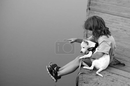 Foto de Lindo niño y cachorro jugando afuera. Una infancia sin preocupaciones. Protección animal doméstico - Imagen libre de derechos