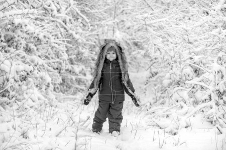 Photo for Funny kid coming to the winter forest on snow landscape. Joyful child Having Fun in Winter Park. Cute toddler boy playing in winter park in snow outdoors - Royalty Free Image