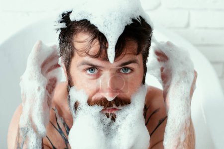 Téléchargez les photos : Homme hipster barbu à longue barbe et moustache. Prendre un bain avec de la mousse de savon. Procédures de bain et toilettage - en image libre de droit