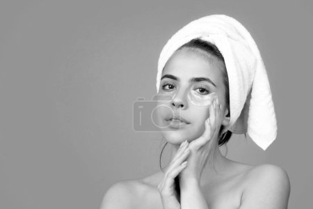 Photo for Facial treatment. Cosmetology beauty and spa. Girl apply skincare cream on face, woman wrap towel on head put facial creme on doing morning healthy skin - Royalty Free Image