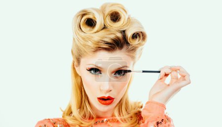 Téléchargez les photos : Eyebrow makeup. Beauty blonde model shaping brows with brow pencil closeup. Beautiful woman contouring eyebrows. Woman portrait isolated on white studio background. Pinup style - en image libre de droit
