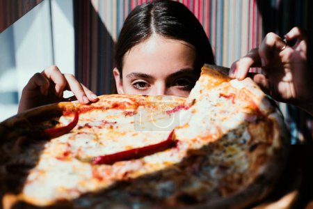 Téléchargez les photos : Pizza girl. Femme avec de la nourriture italienne au restaurant. Femme affamée - en image libre de droit