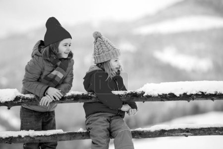 Foto de Niños felices amigos en la nieve. Niña y niño divirtiéndose en el día de invierno - Imagen libre de derechos