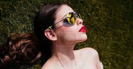 Photo for Spring woman face for banner. Portrait of a young woman relaxing on the grass. Woman lying on the grass - Royalty Free Image