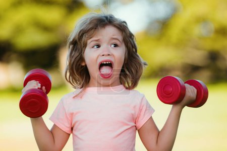 Photo for Kid with dumbbells in park. Child sport. Active boy, healthy lifestyle concept - Royalty Free Image