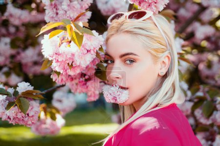 Foto de Hermosa chica en flores rosadas en el parque de flores de verano. - Imagen libre de derechos
