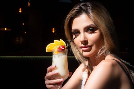 Photo for Pretty modern lady holding cocktail glass. Attractive girl with pina colada - Royalty Free Image