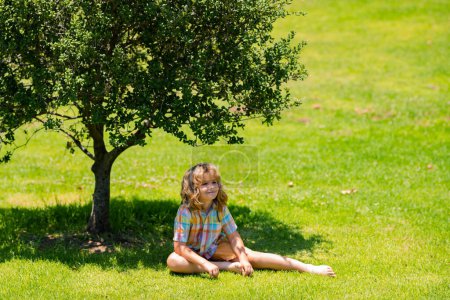 Photo for Child on nature. Kids playing outdoors in spring park. Freedom and carefree. Happy childhood. Relaxing kid in green field on grass during spring - Royalty Free Image