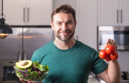 Photo for Portrait of attractive man preparing fresh natural weight loss meal at kitchen home indoors. Handsome cheerful man preparing meal in the kitchen. Healthy food, cooking concept - Royalty Free Image