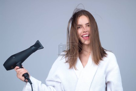 Photo for Woman with hair dryer on studio background. Girl hold hairdryer. Young woman drying hairs with hair dry machine. Beauty girl using dries hairs with hair dryer. Beauti model with holding blow dryer - Royalty Free Image