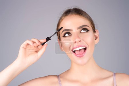 Téléchargez les photos : Woman shaping brown eyebrows. Woman eye with beautiful eyebrows. Shaped brows, long eyelashes. Paint eyebrows. Girl contouring eyebrows on isolated studio background - en image libre de droit