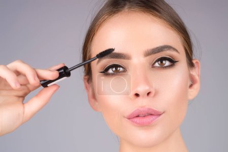 Foto de Female model shaping brown eyebrows. Woman eye with beautiful eyebrows. Perfect shaped brow, eyelashes with brow gel brush. Paint eyebrows - Imagen libre de derechos