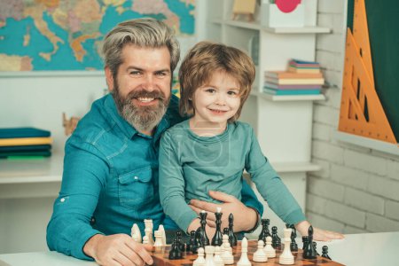 Photo for Teacher and schoolboy playing chess in class. Happy two generations of men have fun and playing Chess. Father and son - Royalty Free Image