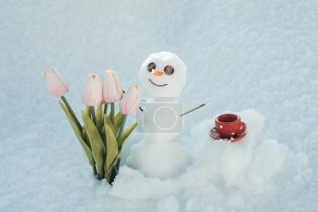 Foto de Hola primavera, adiós invierno. Hombre de nieve con taza de café. Hombre de nieve con flores - Imagen libre de derechos