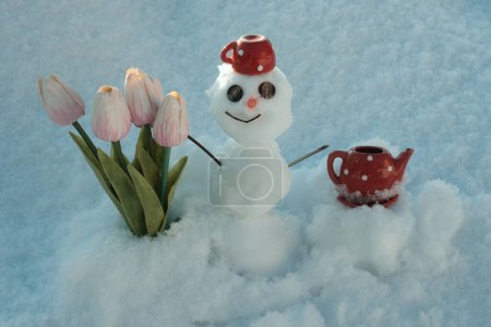 Foto de Muñeco de nieve con flores. Primavera invierno hombre de nieve con taza de café - Imagen libre de derechos