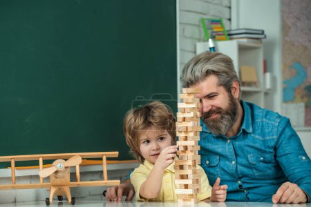 Photo for Funny little child with father having fun on blackboard background. Private child tutor. Educational games - Royalty Free Image