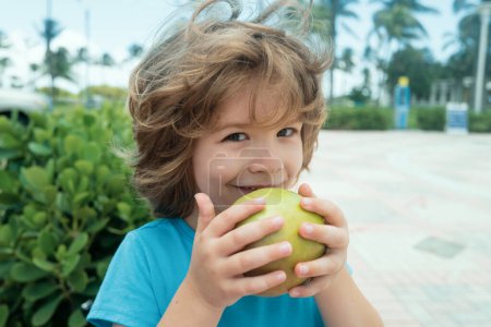 Téléchargez les photos : Un gamin mange des pommes. Une alimentation saine pour les enfants. Une collation aux fruits. Heure du déjeuner - en image libre de droit