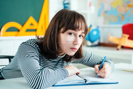 Photo for Learning and education concept. Female Student. Cute Teenager drawing an house and looking at camera. Cute Teenager draw with colorful crayons - Royalty Free Image