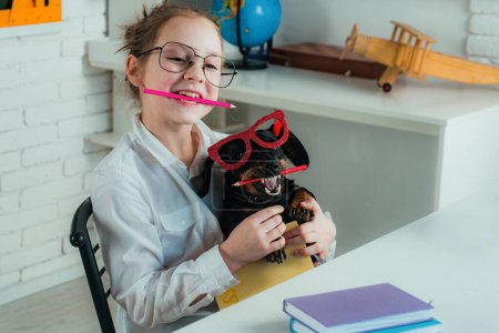 Foto de Concepto de idea de vuelta a la escuela con divertido perro sosteniendo lápiz. Perro inteligente e inteligente con lápiz y gafas - Imagen libre de derechos