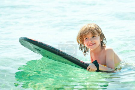 Photo for Kid serfer. Catch the wave. Extreme sport activity. Happy child playing in th sea water - Royalty Free Image