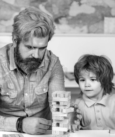 Photo for Father and son building wood blocks at home. Playing Jenga games for meditation practice. Building Computational Skills. Kids play concept - Royalty Free Image
