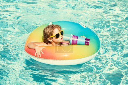 Foto de Niño en el parque acuático, vacaciones de verano. Bebida infantil cóctel en la piscina. Vacaciones de verano - Imagen libre de derechos