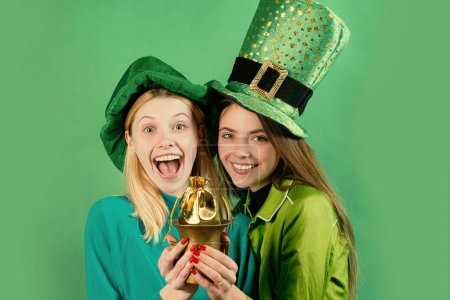 Téléchargez les photos : Jeunes femmes célébrant la St Patricks Day dans un pub. Isolé. Traditions irlandaises - en image libre de droit