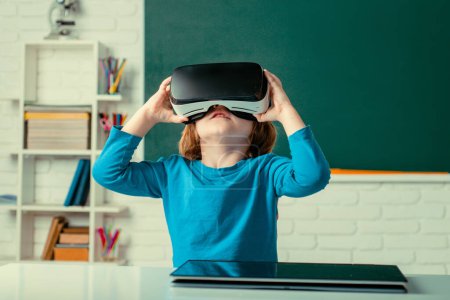 Photo for Pupil with vr goggles in school classroom. Little boy playing with VR glasses - Royalty Free Image